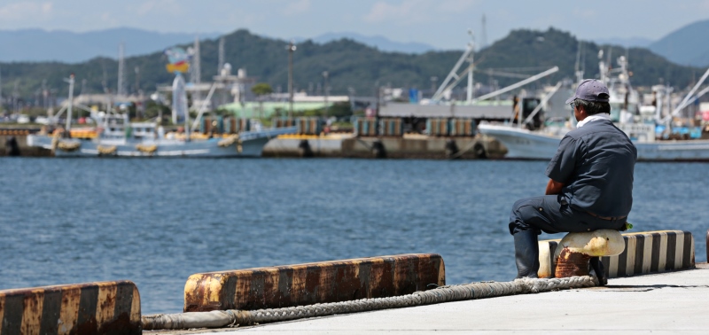 A fisherman looks out to sea in Iwaki, Fukushima Prefecture, after the government announced in August 2013 that it will take “emergency measures” to tackle radioactive water spills at the Fukushima nuclear plant. ©Yuriko Nakao/Bloomberg via Getty Images